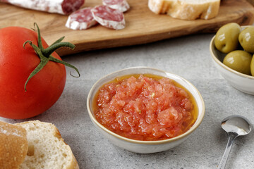 Grated tomato with olive oil in bowl. Catalan typical paste to make bread with tomato (Pa amb tomaquet).