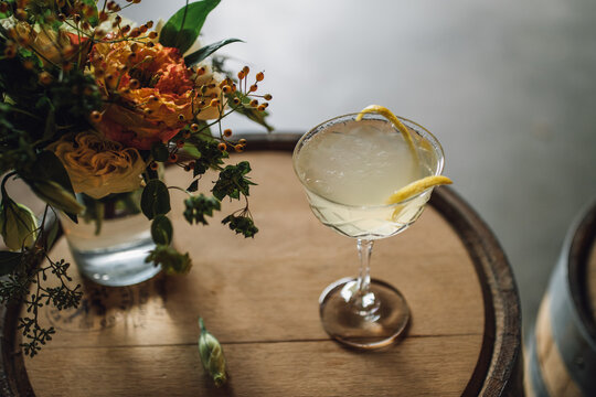 Still Life With Lemon Cocktail And Flowers On Wooden Whiskey Bourbon Barrel 