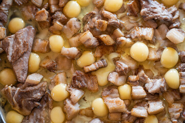 Food background. Scrambled eggs with meat and lard in a large skillet. Delicious food on the street.