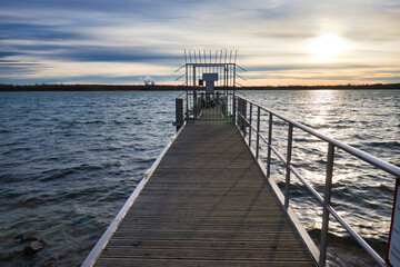 Obraz premium Moderner Bootssteg aus Metall und Holz am Markkleeberger See bei tiefstehender Abendsonne mit Blick über das Wasser, Markkleeberg, Landkreis Leipzig, Sachsen, Deutschland