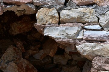 Destroyed old masonry of large stones fastened with clay mortar