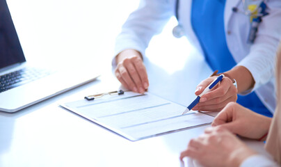 Doctor and patient couple are discussing something,sitting on the desk