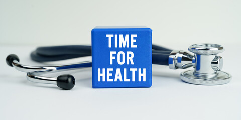 On the table is a stethoscope and a blue cube with the inscription - TIME FOR HEALTH