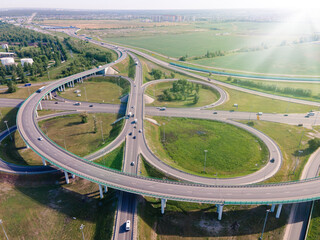 Aerial view of road interchange or highway intersection with traffic speeding on the road. Junction...