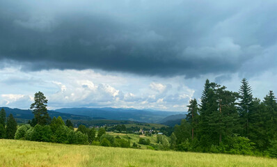 Fototapeta na wymiar landscape with green grass and mountains, Małopolska, dark clouds