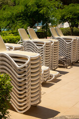 many loungers chairs stacked next the beach