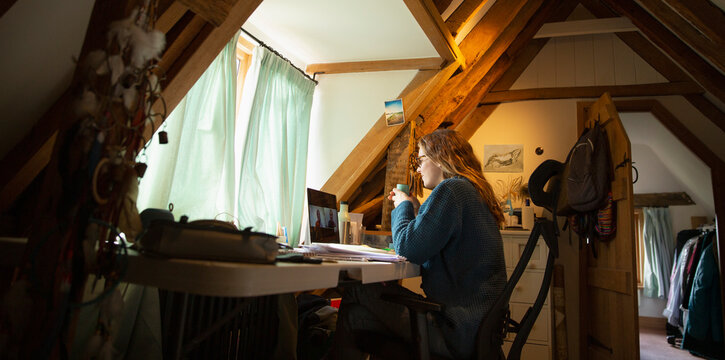 Woman video conferencing at laptop in home office