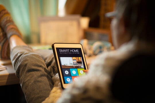Woman looking at smart home automation on digital tablet screen