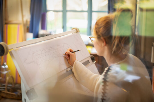 Female architect drafting blueprints in home office