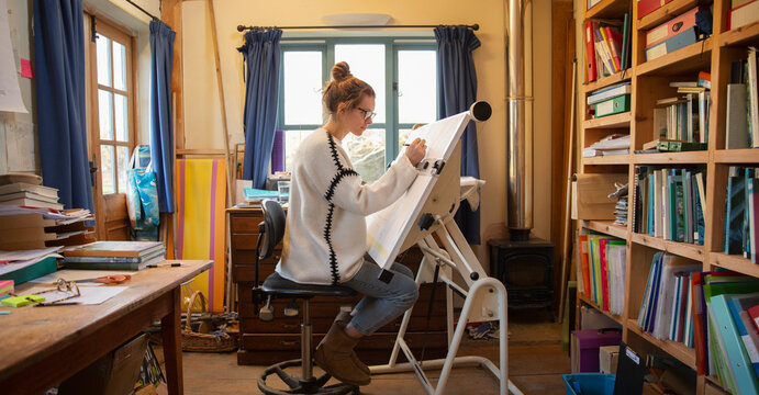 Female architect working at drafting table in home office