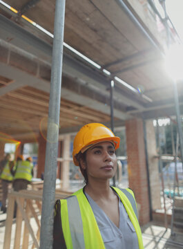 Portrait thoughtful female construction worker at construction site