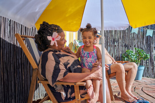 Portrait cute granddaughter with grandmother at summer poolside