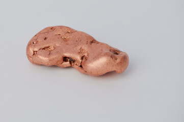 close up of a solid copper nugget on white background with copy space
