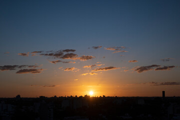 Silueta de la ciudad a contraluz con el sol del atardecer