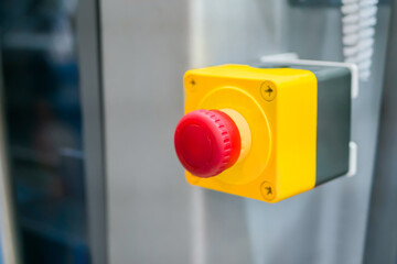 Machine control panel with power red switch button - emergency stop at factory, plant - close up, selective focus. Industrial, electronic, technology equipment concept