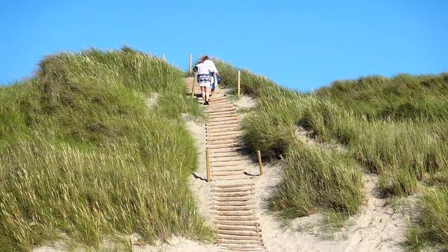 Hirtshals, Denmark A woman walks to the beach through the dunes of northern Denmark on the North Sea coast.