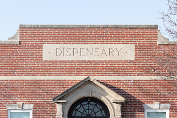 Stone dispensary sign on a brick building—marijuana and cannabis - obrazy, fototapety, plakaty