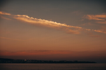 Fototapeta na wymiar Stunning city view with black sea horizon at orange sunset. Summer evening