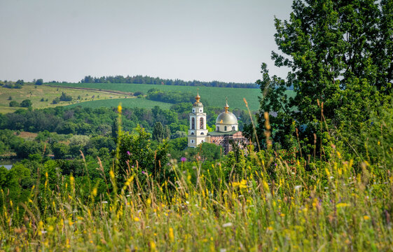 Summer rural landscape and old Christian Orthodox church among green hills