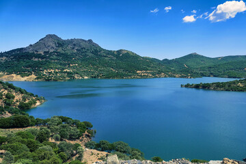 Fototapeta na wymiar A blue lake and sky among green mountains at Gökceada, Imbros Canakkale Turkey. dam, barrage, view
