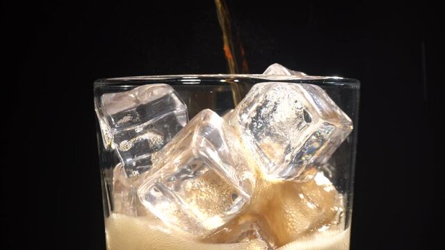 Vertiendo cola en un vaso girando con hielos