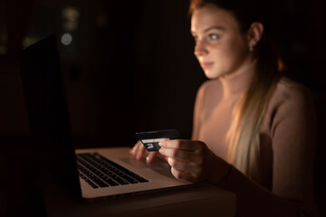 Happy young woman connecting with her laptop and buying gifts wi