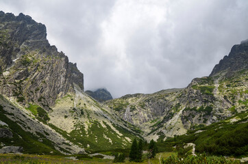 Fototapeta na wymiar Beautiful sharp rocky peaks of mountain ranges under cloudy sky in the High Tatras, Slovakia