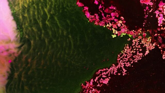 Flowing glitter waving surface. Flowing Golden abstract backdrop. Beautiful metallic green, pink, red, brown texture paint close-up. Liquid slow motion Art. Colorful Chaos Turbulence. 