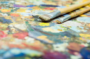 Pincel de pintura al oleo en paleta de colores variados y brillantes. Acrílico multicolor con...