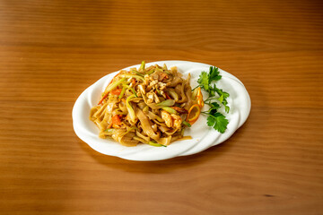 Thick noodles cooked with spicy pad thai recipe with prawns, nuts and fruits and vegetables.