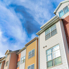 Square Exterior of houses with dormers and balconies beneath scenic skyscape view
