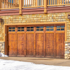 Square Garage entrance with glass panes on the door under balcony of home in Park City