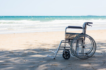 Empty nobody wheelchair on sand of the beach for taking the patient travel