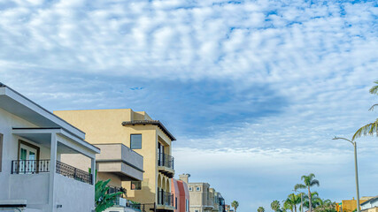Pano Blue sky and puffy clouds in coastal neighborhood of Huntington Beach California