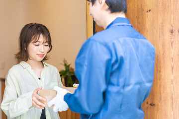 Obraz premium 宅配便・デリバリーを受け取る若い女性