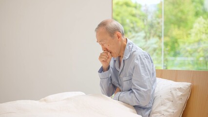 寝室で咳をする高齢者