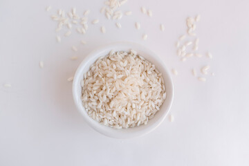 granos de arroz blanco crudo en plato circular fondo blanco