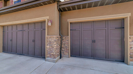 Pano Two car attached garage with gray doors at the facade of a residential house