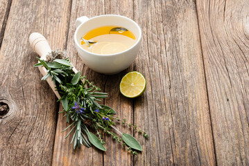 cup of herbal tea and sage, lavender, thyme, iceland lichen herb leaves on scoop