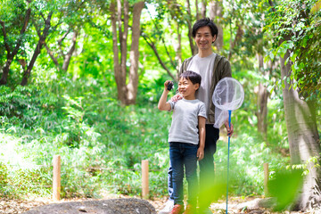 虫取りをするお父さんと男の子