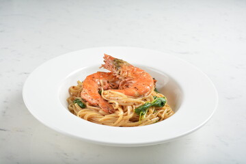 mixed seafood pasta with big tiger prawn, scallop shell clam and muscle in alio olio salted egg yolk paste sauce in white background western halal cuisine 