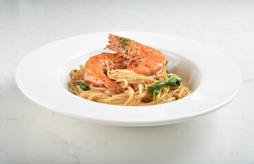 mixed seafood pasta with big tiger prawn, scallop shell clam and muscle in alio olio salted egg yolk paste sauce in white background western halal cuisine 