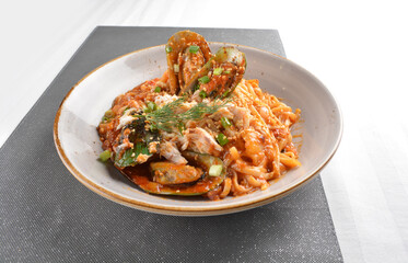 mixed seafood pasta with big tiger prawn, scallop shell clam and muscle in spicy chilli crab sauce or tomato paste sauce in white background western halal cuisine 