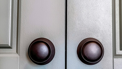 Pano Shiny round black doorknobs installed on the wooden panelled double doors