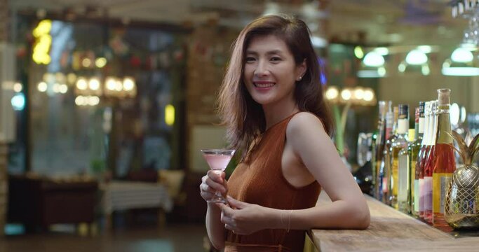 Beautiful woman drinking cocktail in bar,4k