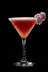 Alcoholic cocktail fairy stream and flower on black background. Copyspace