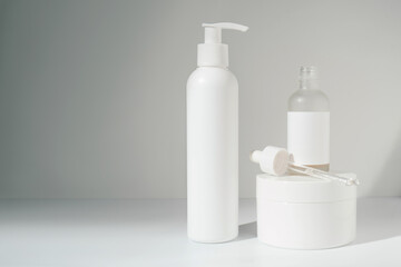 Three jars of cosmetics stand on a white background.