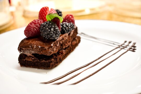 Reposteria Postre pastelillo gourmet de chocolate con frutos rojos emplatado para evento, alta reposterial