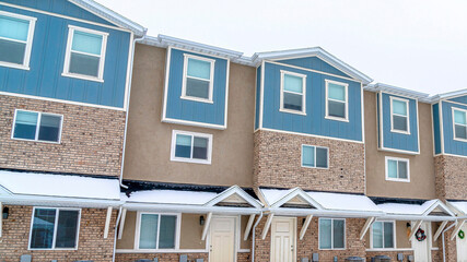 Pano Three storey apartments in a neighborhood landscape with snow and cloudy sky