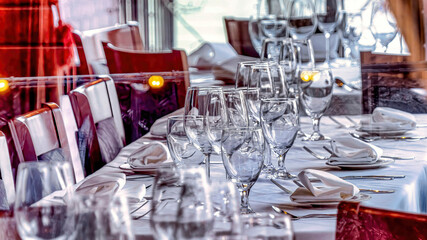 Pano Dinner table setting with wine glasses and tableware seen through glass window